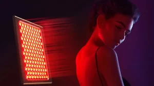 FAQ LED red light therapy - poză pe fundal negru cu lumină roșie