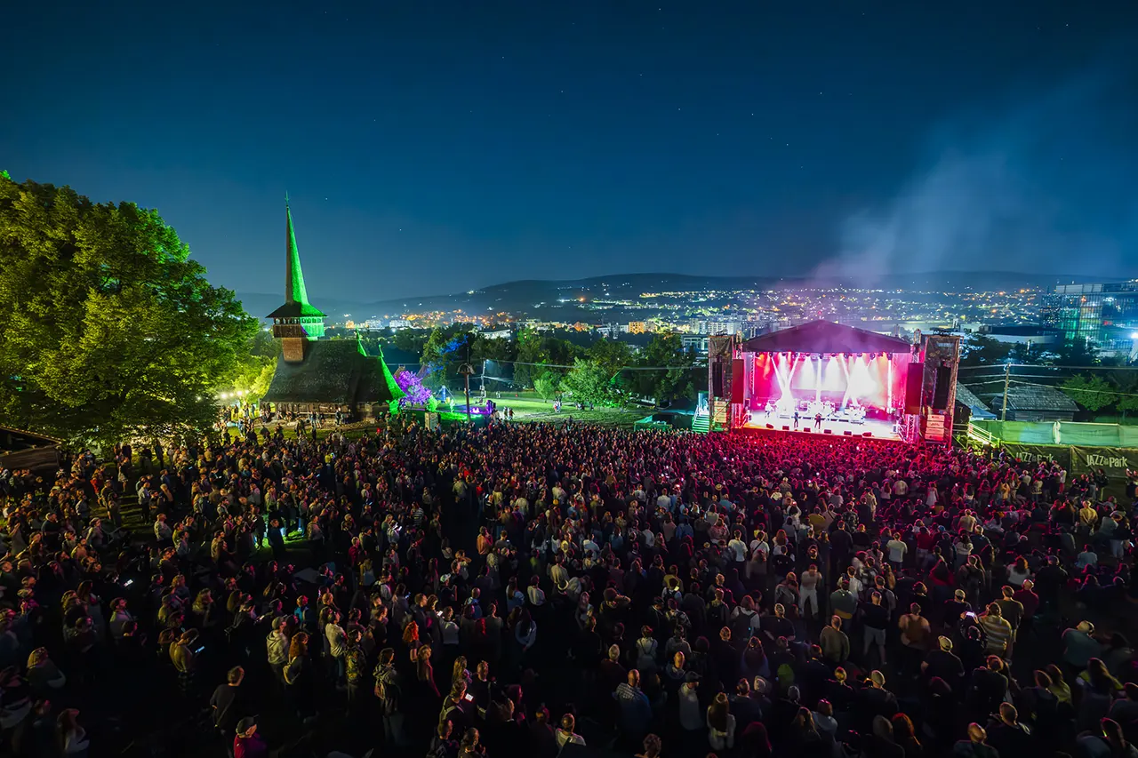 Panoramă de concert de seară la Jazz in the Park, scenă luminată și public