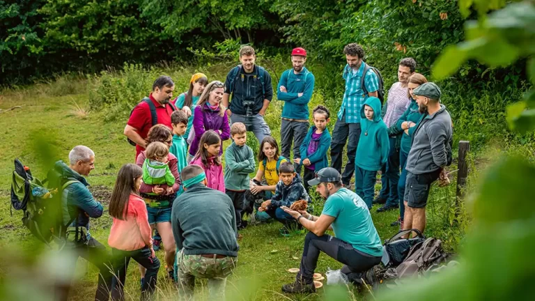 Peste 30 de tururi ghidate, drumeții și experiențe nocturne: ce nu trebuie să ratezi la Făgăraș Fest 2026 Brașov, 17 aprilie 2026. Făgăraș Fest 2026 aduce, între 10 și 12 iulie, la Sebeșu de Sus, cea mai diversă și complexă serie de tururi ghidate de până acum - peste 30 de experiențe în natură care îi scot pe participanți din zona de spectator și îi duc direct în mijlocul Munților Făgăraș. Într-un singur weekend, poți ajunge la cascade, poți observa păsări la răsărit, poți descoperi urmele animalelor sălbatice și poți vedea Munții Făgăraș pe timp de noapte, alături de specialiști. De la primele ore ale dimineții până după lăsarea întunericului, festivalul propune un program care transformă fiecare zi într-o explorare autentică. Participarea se face în grupuri restrânse, alături de ghizi și specialiști, ceea ce face diferența dintre o plimbare și o experiență pe care o ții minte. Programul complet și biletele pentru tururile ghidate sunt disponibile pe https://fagarasfest.ro. Munții Făgăraș, descoperiți pas cu pas Tururile ghidate îi duc pe participanți în mijlocul naturii din Valea Moașei, unde fiecare pas devine o descoperire: de la plante și insecte, până la felul în care toate acestea sunt legate între ele și contribuie la echilibrul naturii. În tururile de faună sau observare a păsărilor, participanții învață să citească semnele naturii: urme, sunete și comportamente care spun povestea vieții sălbatice din Munții Făgăraș. Pentru cei care vor să exploreze mai departe, drumețiile către cascadele de pe Valea Moașei sau traseele spre Cabana Suru oferă combinația perfectă între efort, peisaj și explicații despre zona montană. Programul aduce împreună experiențe pentru toate tipurile de participanți, de la cei care vor să exploreze în ritm relaxat, până la cei care caută aventură: • drumeții către cascadele de pe Valea Moașei și Cabana Suru • tururi despre faună - lilieci, castori, insecte și alte animale sălbatice • explorări dedicate florei, ciupercilor, arborilor și biodiversității • observarea păsărilor și fotografie în natură • experiențe pentru familii — „Exploratorii Munților Făgăraș" • tururi culturale prin satul Sebeșu de Sus • tururi despre viața râului Valea Moașei Fiecare tur oferă o perspectivă diferită asupra naturii și a relației dintre oameni și acest peisaj. După lăsarea serii, natura arată altfel Unele dintre cele mai căutate experiențe de la Făgăraș Fest au loc după lăsarea serii. Tururile nocturne dedicate liliecilor dezvăluie o lume invizibilă ziua, folosind echipamente speciale care transformă ultrasunetele în ceva ce poți auzi și înțelege pe loc. Tururile despre viața din râuri, cele dedicate insectelor sau ciupercilor și experiențele de pescuit la muscă artificială aduc perspective diferite asupra naturii. Participanții descoperă nu doar tehnica, ci și echilibrul delicat al ecosistemelor acvatice și află cum sunt monitorizate animalele sălbatice, prin urme și tehnologii non-invazive, dar și conviețuirea cu animalele sălbatice. Tururile nu sunt simple plimbări, ci ocazii de a înțelege cum funcționează natura, de la relațiile dintre specii până la rolul fiecărui element din ecosistem. Natură, comunitate și experiențe pentru toate vârstele „Exploratorii Munților Făgăraș" transformă explorarea naturii într-o aventură de echipă pentru copii și părinți, cu provocări, jocuri și descoperiri interactive. Drumeția „Darurile naturii" oferă o incursiune ghidată în pădurile din Valea Moașei, unde participanții învață ce înseamnă o drumeție responsabilă: de la echipament și siguranță, până la modul în care ne putem bucura de natură cu un impact cât mai redus. „Colțul Liliecilor" combină știința cu creativitatea. Participanții ascultă ultrasunete, descoperă rolul liliecilor în ecosistem și învață, prin activități creative, cum pot contribui la protejarea lor. Prin tururile ghidate din satul Sebeșu de Sus, participanții descoperă istoria, identitatea și oamenii locului și înțeleg mai bine comunitatea. Explorare pe două roți Pentru cei care vor să acopere mai mult teren, festivalul include ture ghidate cu biciclete electrice pe trasee de 12–16 kilometri în jurul Sebeșului de Sus, în grupuri mici, cu echipament inclus. Varianta freeride oferă libertatea de a explora zona în ritmul tău. Munții Făgăraș nu se văd doar... se ascultă, se miros, se înțeleg. La Făgăraș Fest, tot ce nu se vede se simte. Făgăraș Fest este un festival organizat de Fundația Conservation Carpathia și Primăria Comunei Racovița. Aflat la ediția a VII-a, evenimentul se desfășoară în perioada 10–12 iulie, pe Valea Moașei, la Sebeșu de Sus, într-un cadru natural deosebit, unde participanții pot descoperi natura prin tururi ghidate, drumeții, activități în aer liber și concerte. Făgăraș Fest este realizat cu sprijinul Unicredit Bank, Aenova și Erste Asset Management, în parteneriat cu Consiliul Județean Sibiu. Parteneri media: Radio Guerrilla, Radio România Cultural, Radio Itsy Bitsy, Rock FM Brașov, Magic FM Brașov, Cărturești, Sibiu100, Zile și Nopți, La pas prin Brașov. Despre Fundația Conservation Carpathia Fundația Conservation Carpathia este cel mai mare proiect de conservare a naturii din Europa, care contribuie la refacerea ecosistemelor naturale din Munții Carpați, în beneficiul biodiversității și a comunităților locale. Din 2009, fundația românească a salvat de la exploatare peste 28.000 de hectare de păduri și pășuni alpine în sud estul Carpaților Meridionali, achiziționându-le cu scop de conservare, a plantat peste 4,5 milioane de puieți pe 1.991 de hectare afectate de tăieri, a creat o zonă de 78.000 de hectare pe care nu se desfășoară vânătoare sportivă și de trofee. Fundația contribuie la bunăstarea comunităților din vecinătatea pădurilor protejate prin proiecte sociale, de educație și de dezvoltare de afaceri verzi, iar viziunea pe termen lung este crearea Parcului Național Munții Făgăraș. Activitatea Fundației Conservation Carpathia este recunoscută la nivel național și internațional, recent organizația primind trofeul BAMBI, cel mai important premiu media din Germania, pentru categoria „Planeta Noastră”. Din 1948, BAMBI premiază personalități și organizații care se remarcă prin activitate și au un impact deosebit.