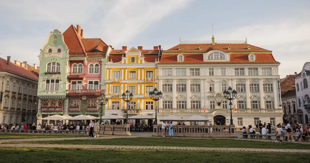 Piața Unirii din Timișoara, cu clădiri istorice și oameni pe spațiul verde - timisoara literara