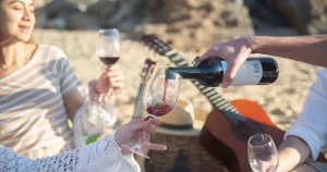 Vin roșu turnat într-un pahar la o întâlnire în aer liber vara