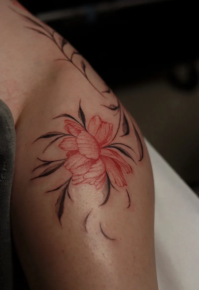 Tatuaj floral cu accente roșii realizat de Daria Stoica