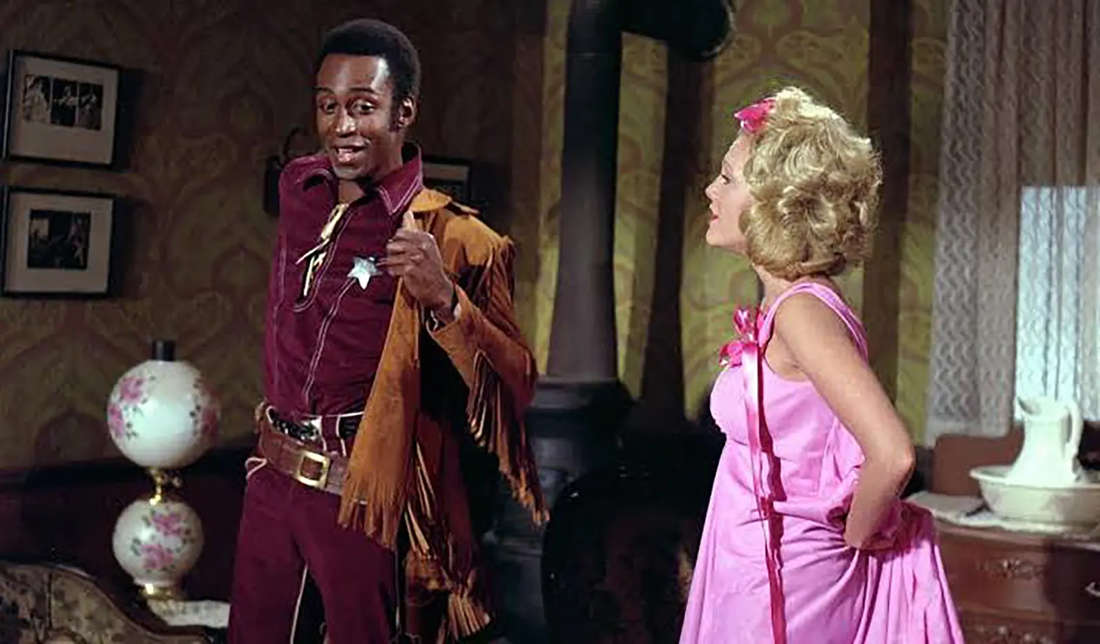 Un șerif și o femeie în costum roz într-o scenă din Blazing Saddles (1974)