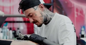 Dani Pralea, artist tatuator din București, lucrând la un tatuaj în studio.