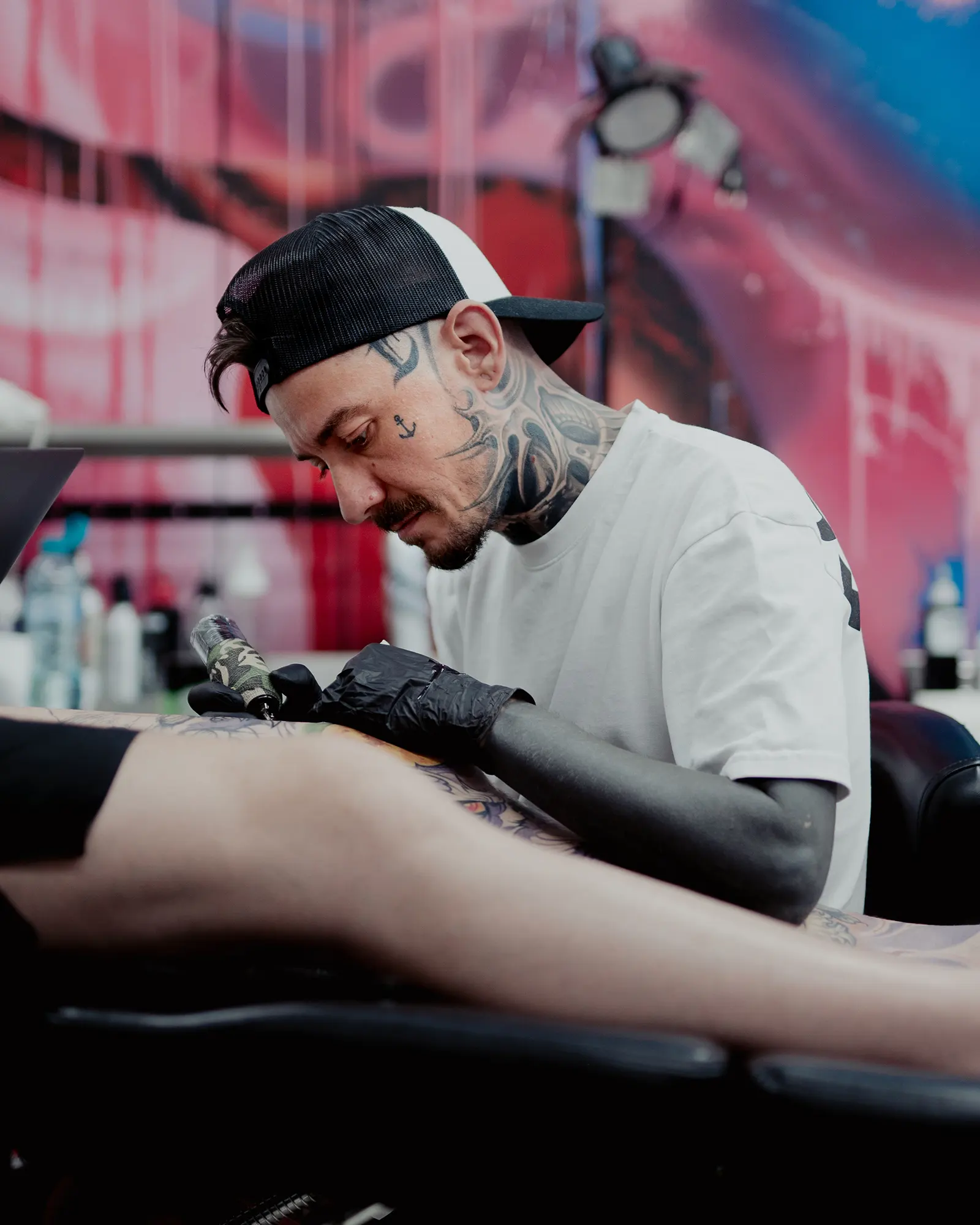 Dani Pralea realizând un tatuaj într-un studio, concentrat asupra detaliilor lucrării.