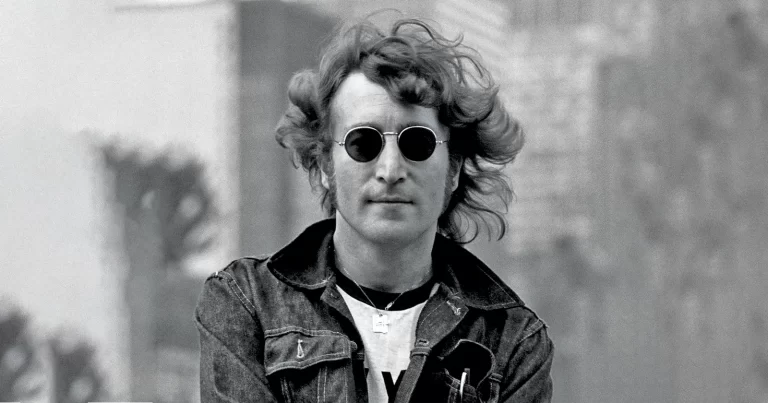 John Lennon cu ochelari rotunzi și geacă denim, portret alb-negru