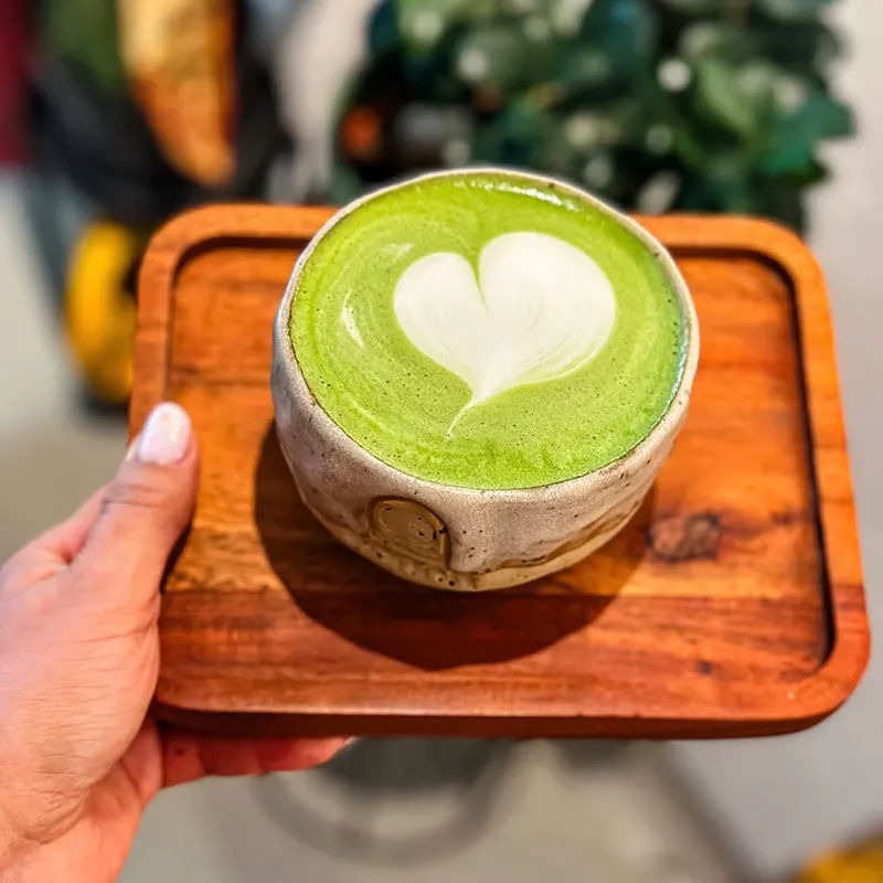 Matcha latte verde cu inimă din spumă într-o ceașcă ceramică la Sahar| matcha în București