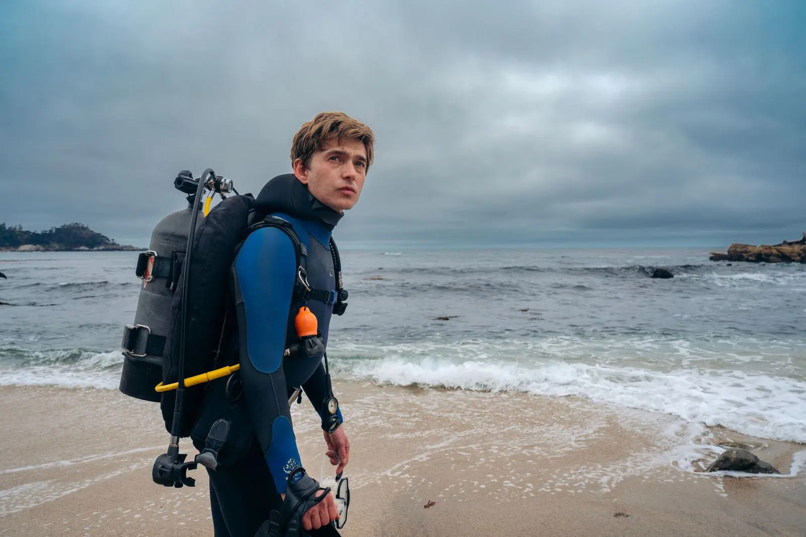 Austin Abrams în echipament de scufundare pe malul oceanului în Whalefall