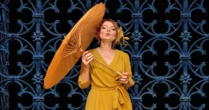 Raluca Stoica, solista Ninigra, într-o fotografie de prezentare cu umbrelă galbenă